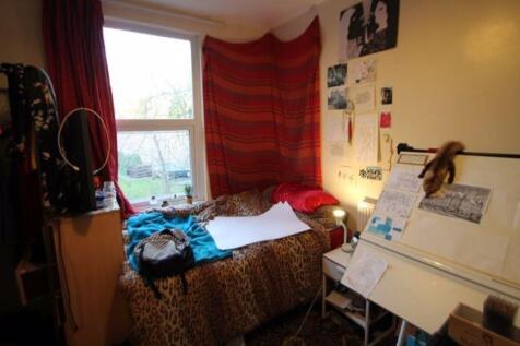 A cozy single bedroom with a large window allow...