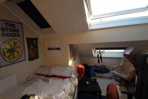 Cozy attic bedroom featuring a sloped ceiling w...