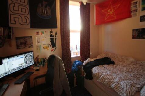 Cozy single bedroom featuring a comfortable bed...