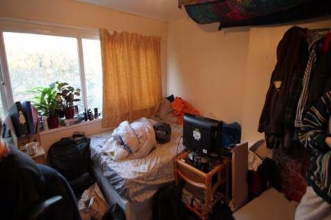 Cozy single bedroom featuring a large window wi...