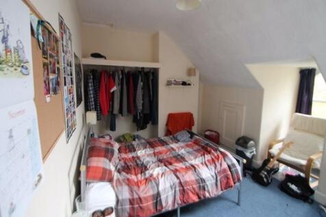 Cozy bedroom with a double bed covered in plaid...