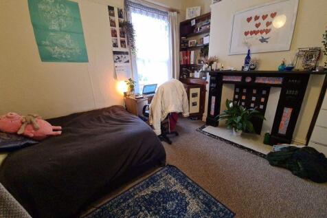 A cozy bedroom featuring a double bed, a study ...