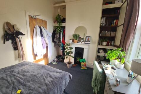 A well-lit bedroom featuring a large bed, ample...