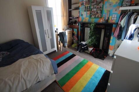 A bright and cozy bedroom featuring a bed, a co...