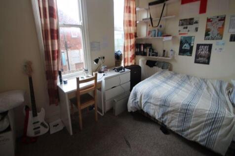 A cozy bedroom featuring a single bed, a study ...