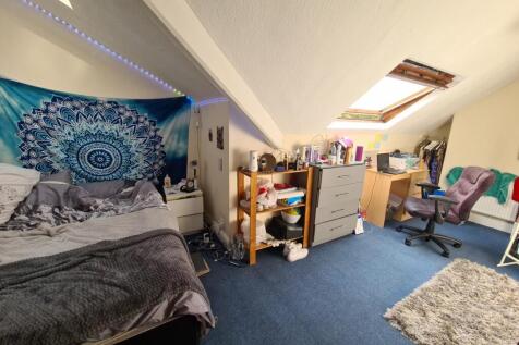 A cozy bedroom featuring a bed with a vibrant t...