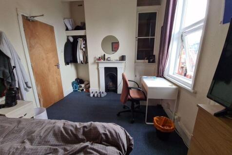 A cozy bedroom featuring a bed, a window provid...