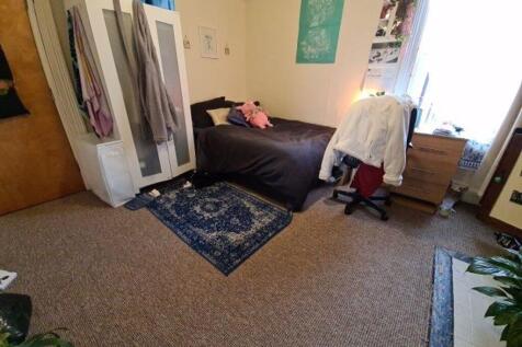 A cozy single bedroom featuring a comfortable b...