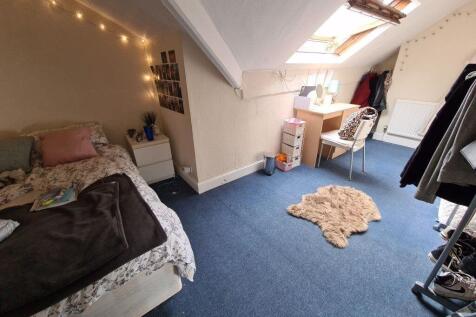 A cozy bedroom with a bed, some furniture, and ...