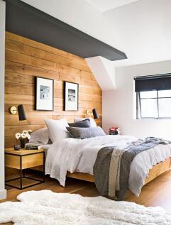 A stylish master bedroom featuring a cozy woode...