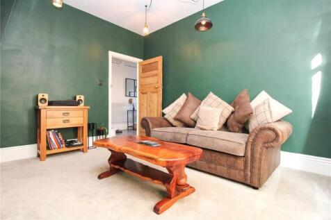 This charming living room features a cozy brown...