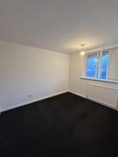 A neat and simple bedroom with clean white wall...