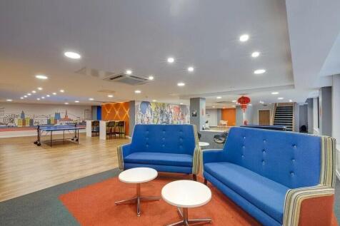 A spacious and vibrant communal lounge featurin...