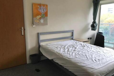 A bright double bedroom featuring a large windo...