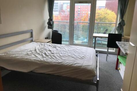 A bright double bedroom featuring a large windo...