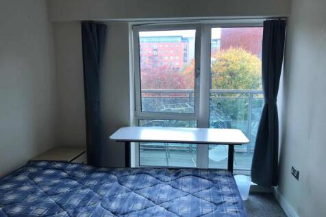 Bright single bedroom featuring a large window ...