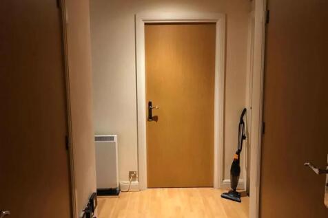 A neat and tidy hallway with light wood floorin...