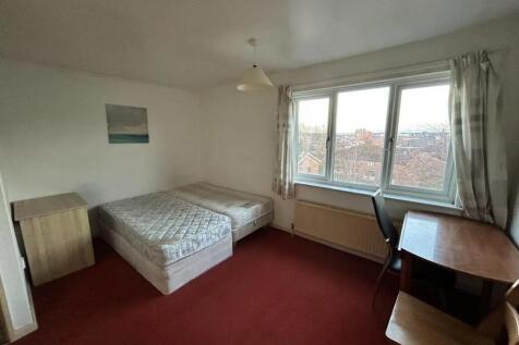 A bright double bedroom featuring a large windo...