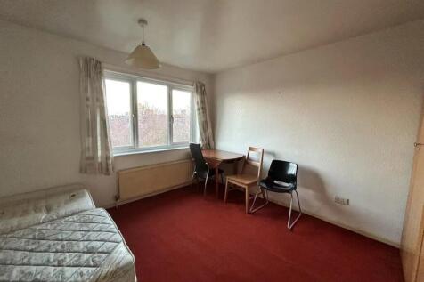 A bright single bedroom with a large window pro...
