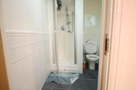 A compact bathroom featuring a walk-in shower w...