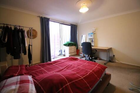 A spacious master bedroom featuring a comfortab...