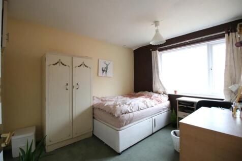 Cozy single bedroom featuring a comfortable bed...