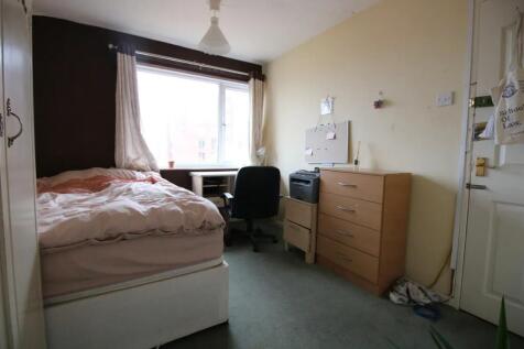 A cozy single bedroom featuring a comfortable b...