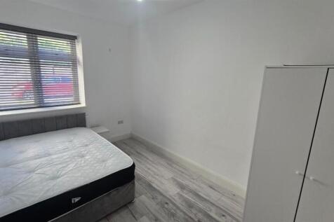 A bright and tidy student bedroom featuring a d...