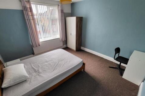 A tidy and well-lit single bedroom featuring a ...