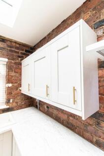 Bright modern kitchen with white shaker-style w...