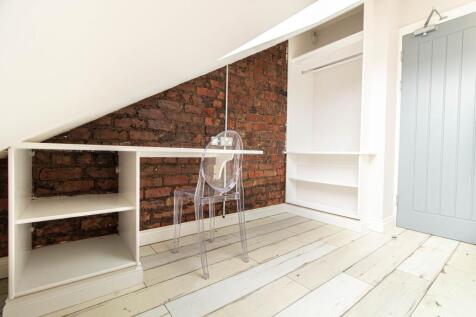 Bright attic bedroom with exposed brick accent ...