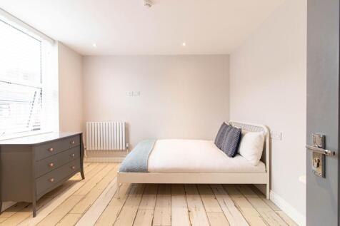 Bright, modern double bedroom with clean white ...