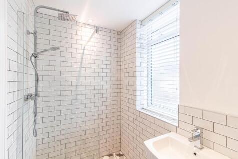 Bright, modern bathroom with a walk-in shower f...