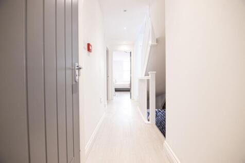 Bright, freshly painted hallway with light wood...