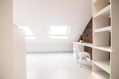 Bright, minimalist attic workspace with two sky...
