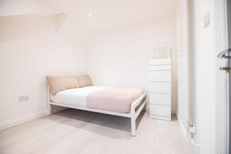 Bright, minimalist double bedroom with a white ...