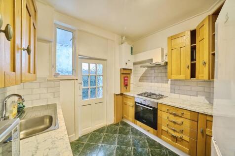 Well-appointed kitchen with wooden cabinetry, m...