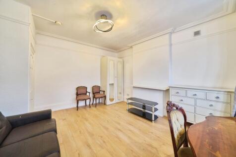Bright, neutral living room with light wood flo...