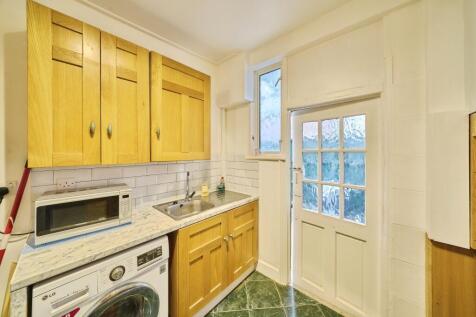 Bright compact kitchen with wooden wall and bas...