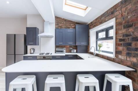 Modern kitchen with a large white island and se...
