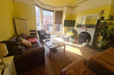 A bright and welcoming living room featuring la...