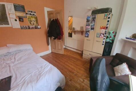 A cozy double bedroom with warm wooden flooring...