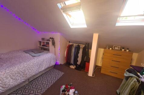 Bright and cozy attic bedroom featuring two sky...