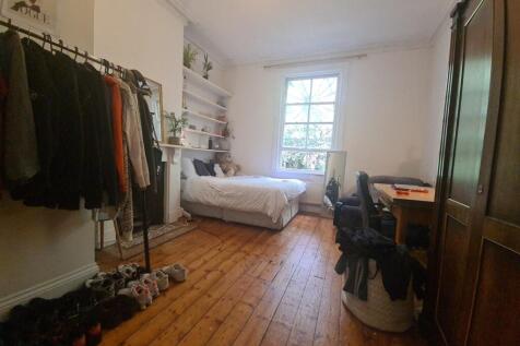 A cozy and neatly organized bedroom featuring a...