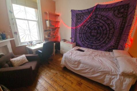 A cozy single bedroom with a comfortable bed, a...