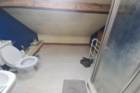 A bathroom featuring a shower enclosure and a t...