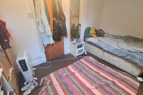 A cozy single bedroom featuring a comfortable b...