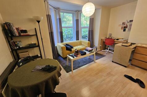 A cozy living room featuring a bright bay windo...