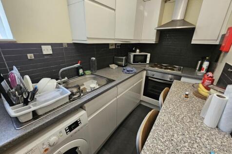 A modern kitchen featuring light cabinetry and ...
