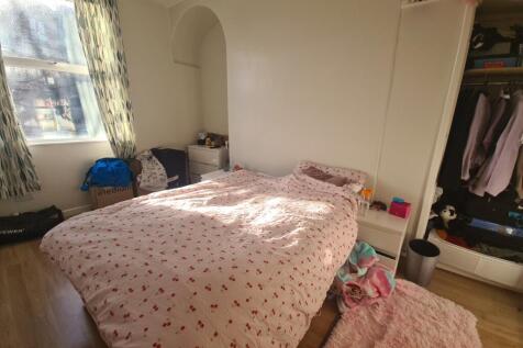 A bright double bedroom featuring a large windo...